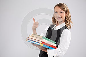 A girl with textbooks shows that she is doing well and great.