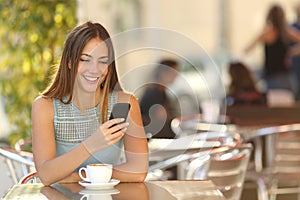 Girl texting on the phone in a restaurant photo