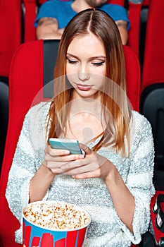 Girl texting sms in cinema
