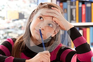 Girl thinking while doing homework