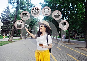 Girl thinks what to eat. Augmented reality. A woman with a smartphone is looking for places to eat in a foreign city. Difficult