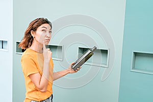 Girl thought about sorting garbage. In the hands of holds two glass bottles as household waste