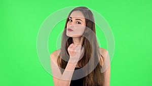 Girl threatens with a fist. Green screen