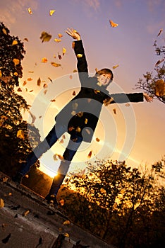 Girl throwing autumn leaves