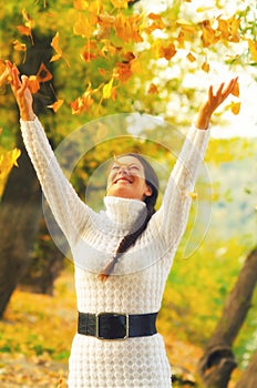 Girl throwing autumn leaves in the air