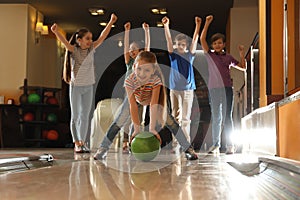 Girl throwing ball and spending time with friends in bowling