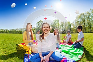 Girl throwing colorful balls playing with friends