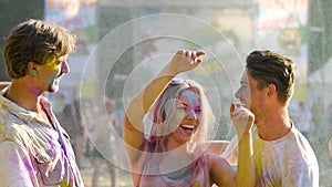 Girl throwing colorful powder above head, best friends dancing at Holi festival