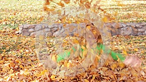 Girl Throwing Golden Fall Leaves into Air