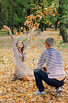 Girl throwing leaves in park