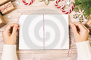 girl tie Christmas letters in envelope, children santa claus letter in envelope, christmas background. Toned