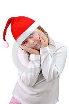 Girl with tilted head in Santa's red hat isolated