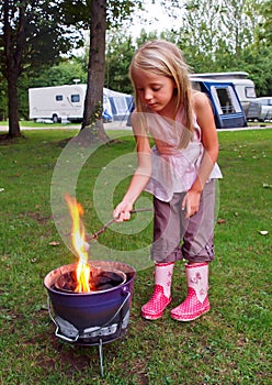 Girl toasting marshmallows on Camp Fire photo