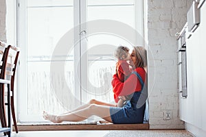 Girl with a toddler boy is sitting at the threshold