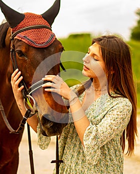 girl together with a horse. caresses the animal& x27;s head with affection.