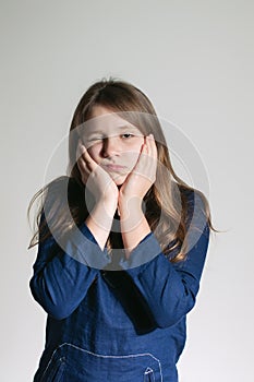 A girl with a tooth pain holding her cheeks with both arms