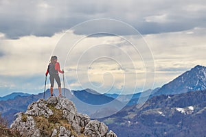 Girl on top of a mountain alone observes the view