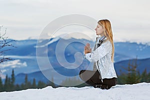 Girl on top of a mountain doing yoga