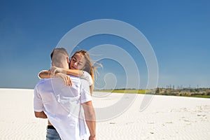 The girl touches a beloved man touchingly while the wind waves her blond hair
