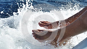 Girl touches the feet of a wave, a background of blue sea water