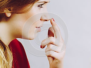 Girl touching her nose, side view