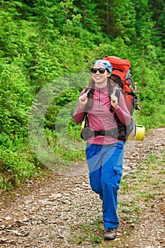 Girl tourist with a backpack going to the mountain