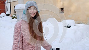 Girl tourist during her vacation listening to music via headphones and dancing in old city center