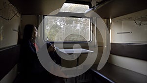 Girl tourist is looking out the train window.