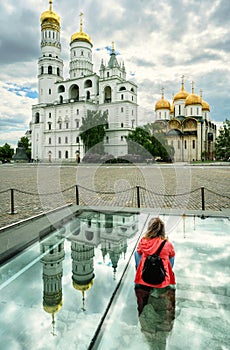 Girl tourist in Moscow Kremlin, Russia. Person looks at old  cathedrals