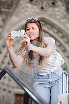 Girl tourist is taking photo on her phone