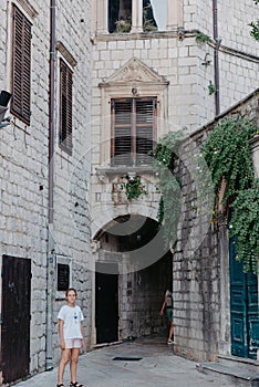 Girl Tourist Walking Through Ancient Narrow Street On A Beautiful Summer Day In MEDITERRANEAN MEDIEVAL CITY, OLD TOWN