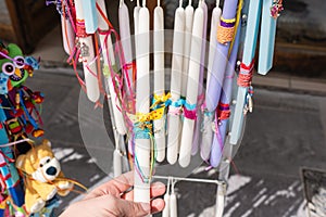 Girl tourist walking in the old souvenir market. Woman hand choosing colorful Easter candles in the Cretan store.