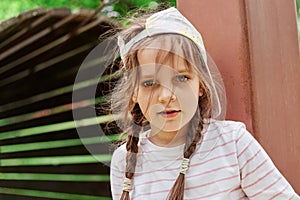 girl with tousled hair climbs pipes on modern and safe children\'s playground, round and long tunnel, overcome obstacles,