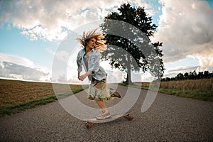 girl with tousled hair glides on her longboard.