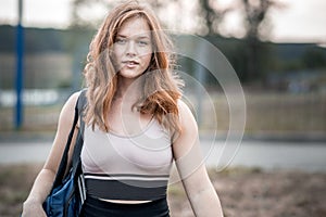 a girl with tousled red hair goes to fitness