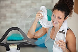 girl towelling off after exercising on step machine