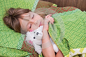 Girl with toy dog on the bed