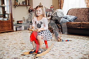 Girl on a toy horse at home