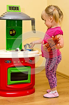 Girl and toy kitchen