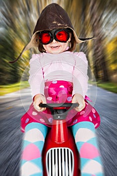 Girl on toy racing car