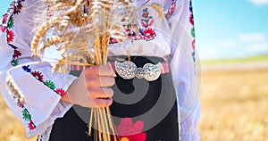 Girl in traditional ethnic folklore costume with Bulgarian embroidery,belt buckle standing on wheat field