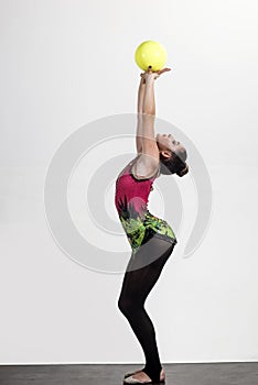 Girl train acrobatics with ball in sportswear. girl training with sport ball isolated on white.