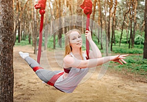 Girl trains in a hammock for aero yoga