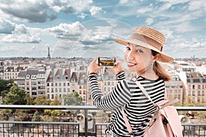 Girl travel blogger taking photo of Parisian cityscape by cell phone. Tourist destinations and mobile photography concept