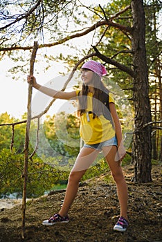 Girl traveler with backpack in hill forest. Adventure, travel, tourism concept