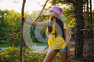 Girl traveler with backpack in hill forest. Adventure, travel, tourism concept