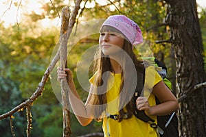 Girl traveler with backpack in hill forest. Adventure, travel, tourism concept