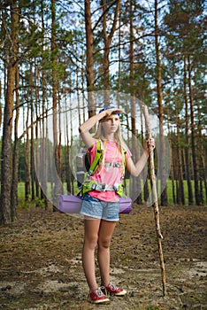 Girl traveler with backpack looks into distance. Travel and tourism concept