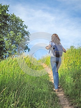 Girl Traveler hiking with backpack at Alpine meadows. Travel Lifestyle concept adventure summer vacations outdoor.