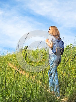 Girl Traveler hiking with backpack at Alpine meadows. Travel Lifestyle concept adventure summer vacations outdoor.